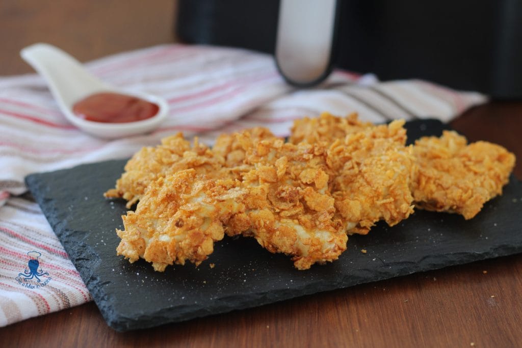 Pedaços de frango com cornflakes na fritadeira a ar