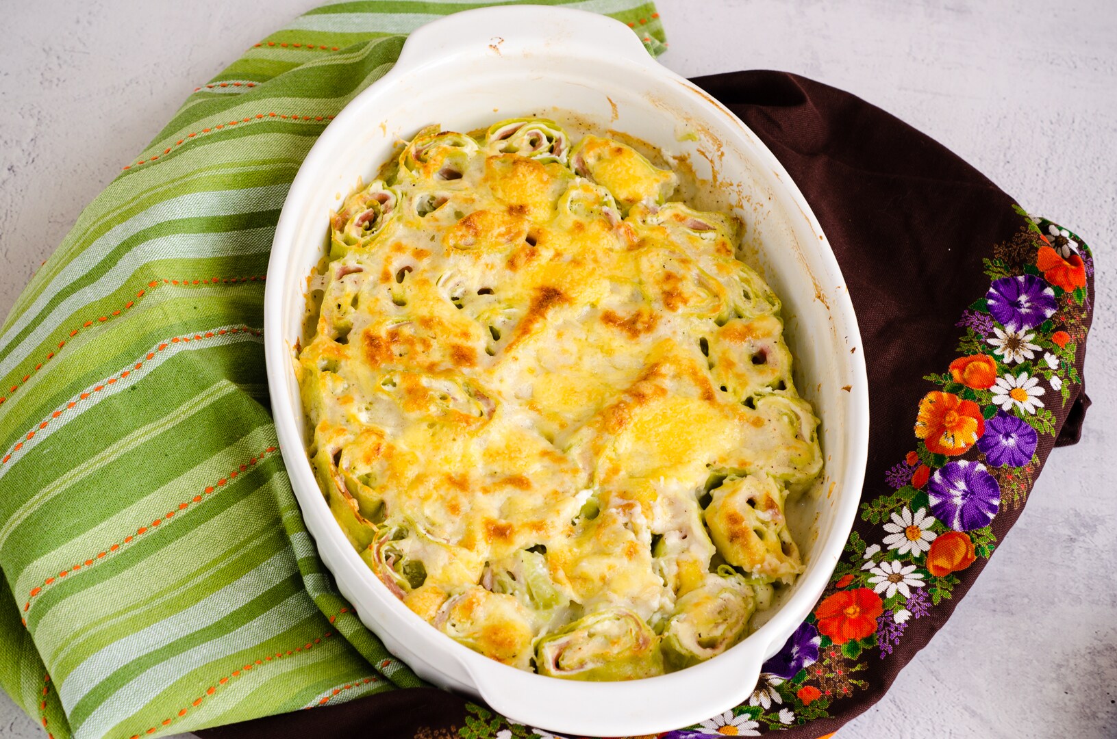 Rolinhos de lasanha verde com presunto e queijo