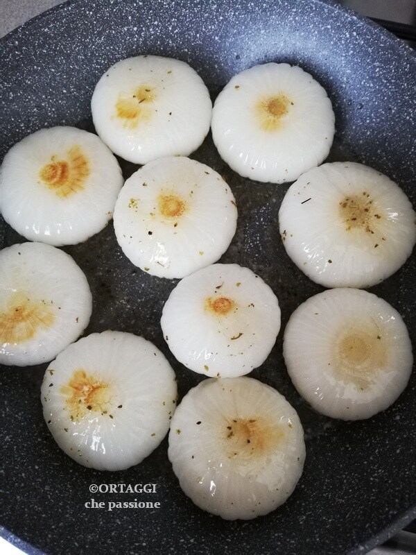 cozinhar em ambos os lados as cebolas na frigideira inteiras