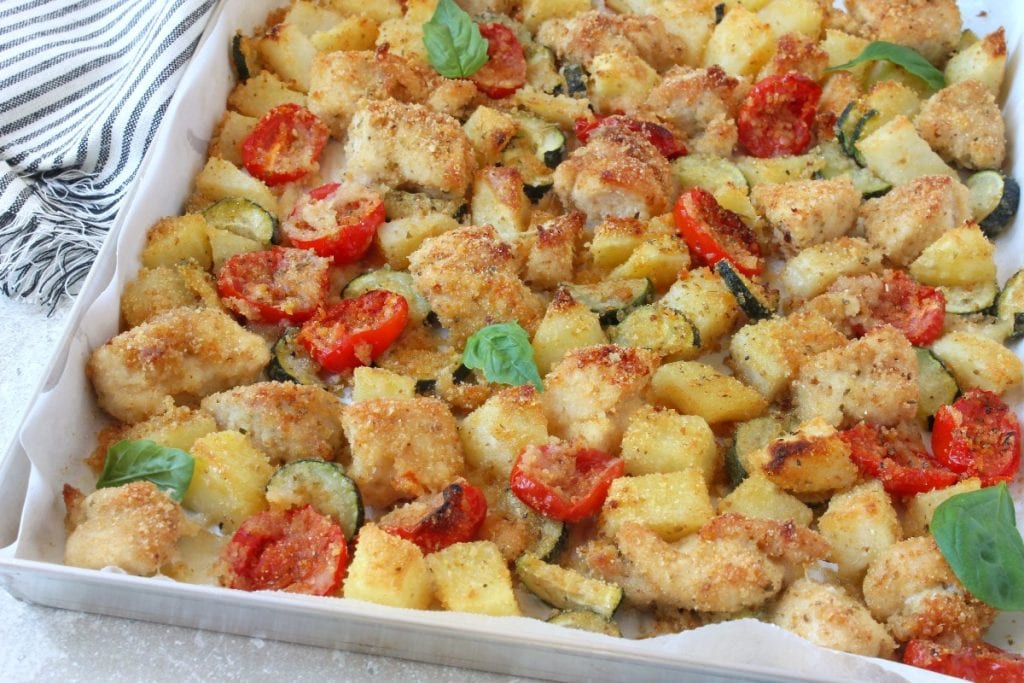 pedacinhos de frango assado com batatas, abobrinhas e tomatinhos