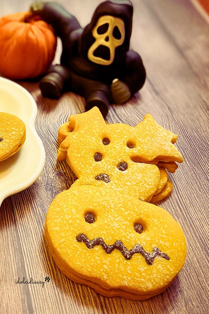 Biscoitos Halloween de massa folhada em forma de abóbora e morcego com decorações de chocolate, ideais para a festa de Halloween