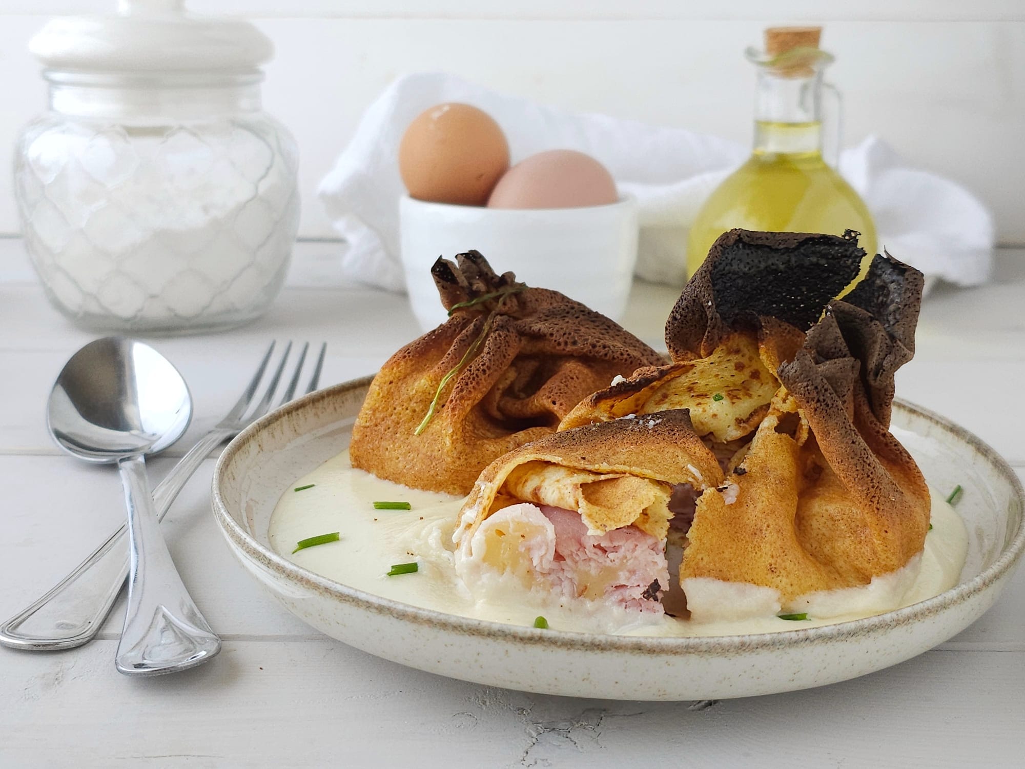 Trouxinhas de crepes à valdostana em cama de fondue de parmesão