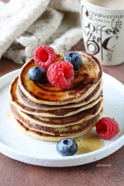 sirva as panquecas com xarope de bordo e frutas frescas