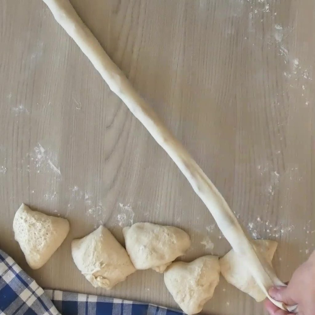 focaccia na frigideira com linguiça e azeitonas alongando rolo