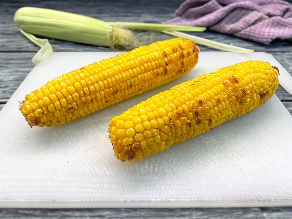 Espigas de milho na manteiga na fritadeira elétrica