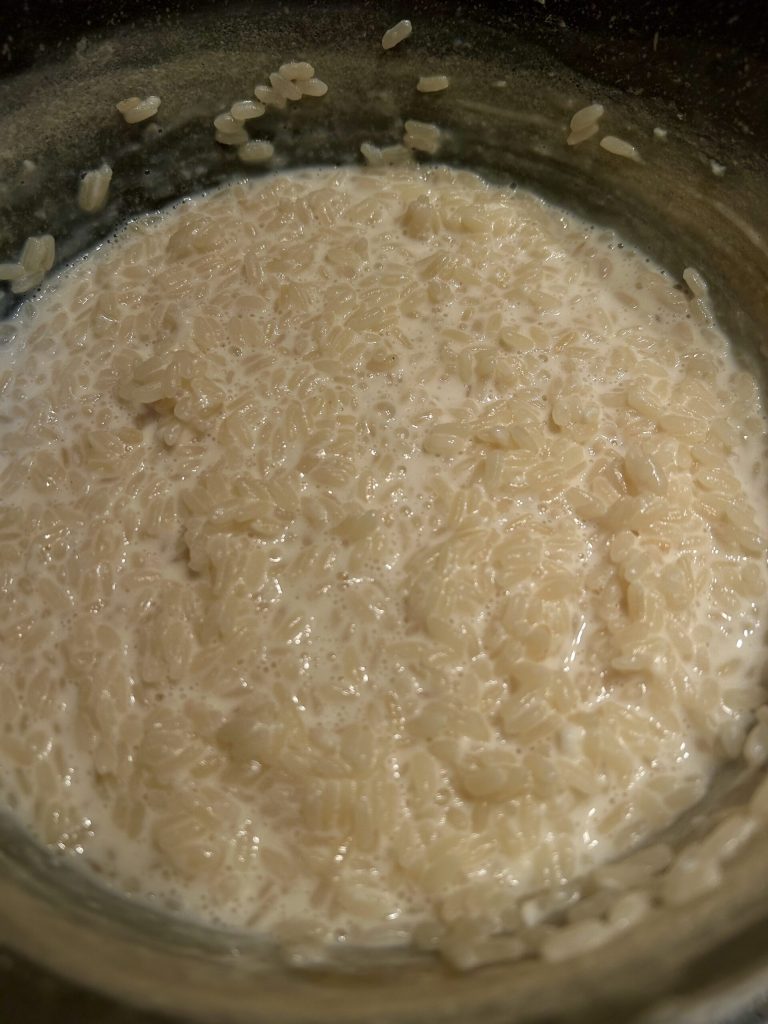 Arroz cozido no leite para preparar os bolinhos de arroz toscanos
