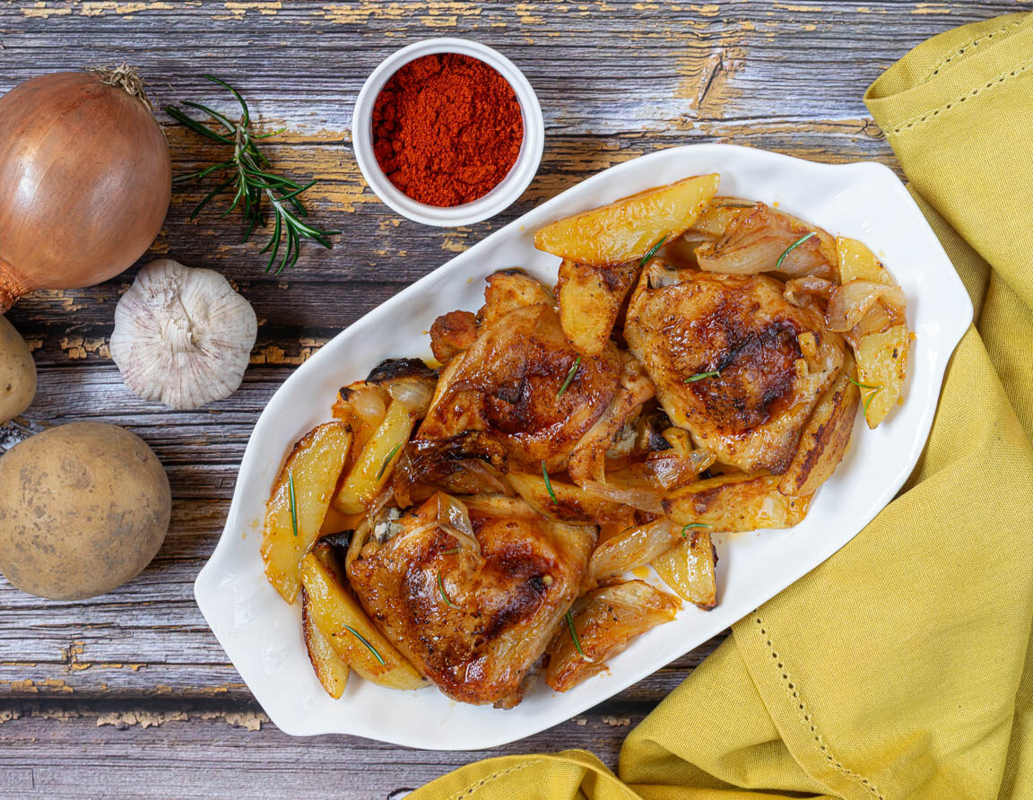 Coxas de frango com batatas e cebolas assadas
