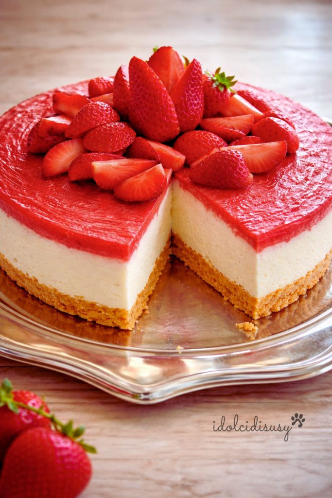 Cheesecake de morango sem forno com fatia cortada, base de biscoito e creme de queijo decorado com morangos frescos