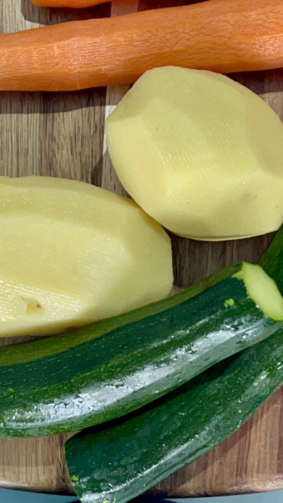 batatas, abobrinhas e cenouras cruas na tábua antes do preparo