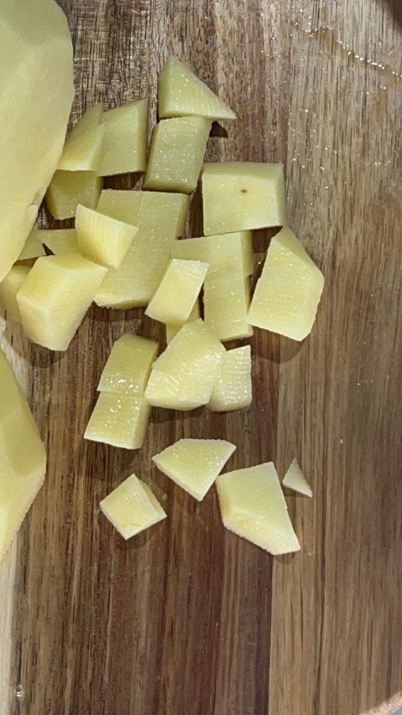 batatas cortadas em cubos para preparar batatas, abobrinhas e cenouras cozidas