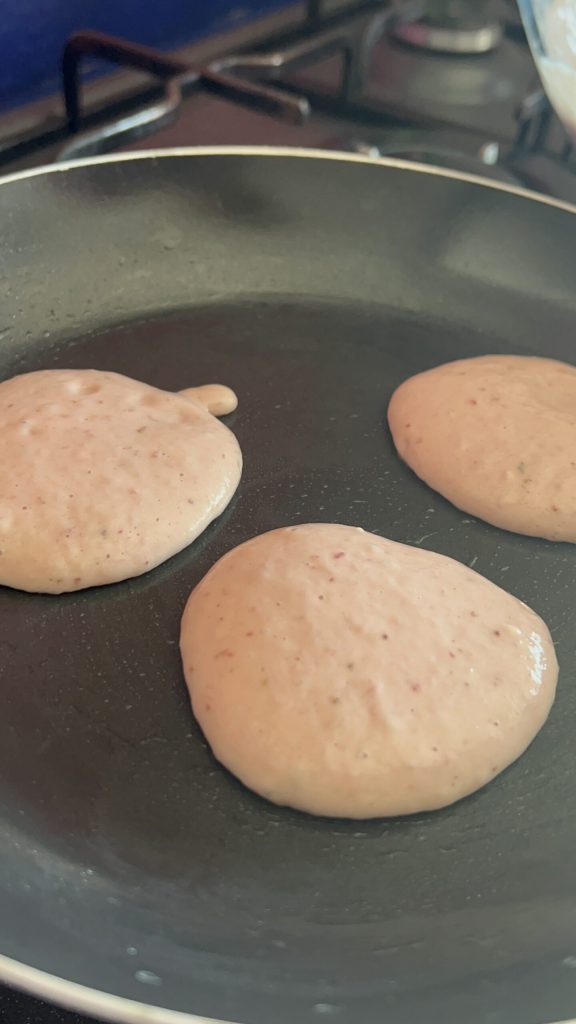 panquecas de morango cozinhando em frigideira antiaderente