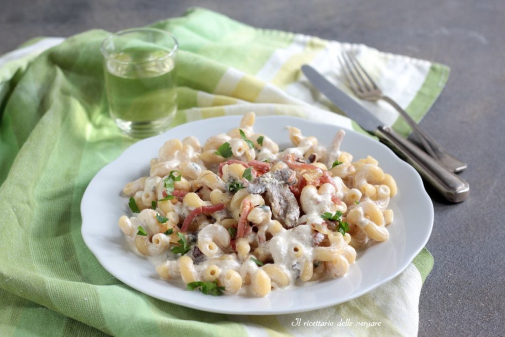 Prato de macarrão boscaiola com cellentani, creme de cogumelos e speck crocante.