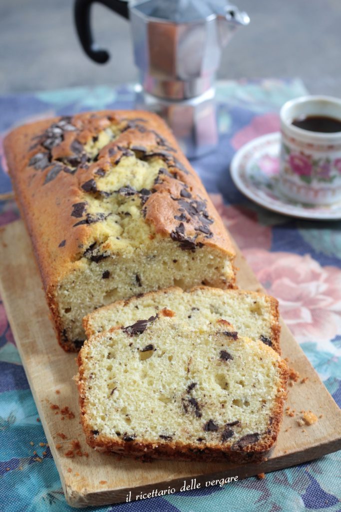 Plumcake dos 7 potes de iogurte com chocolate inteiro sobre uma tábua com gotas de chocolate por cima