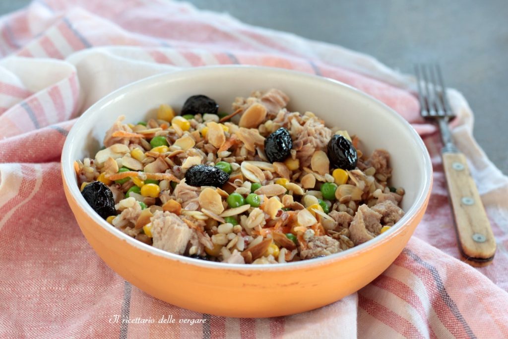 Salada de três cereais com atum, amêndoas tostadas e azeitonas pretas em uma tigela laranja