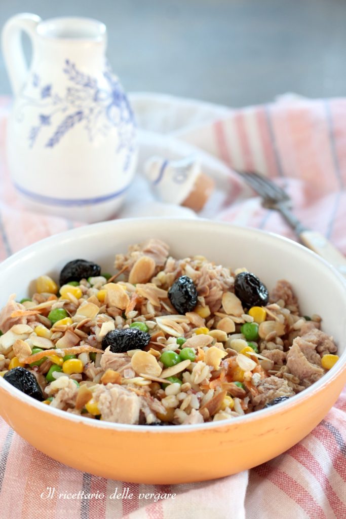 Close-up vertical de uma salada fria de três cereais com atum e amêndoas tostadas