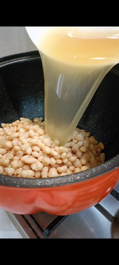 We voegen de bonen en kookwater van de bonen toe