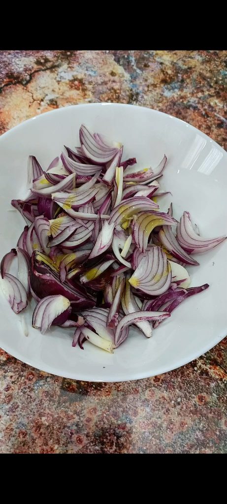 Uien gekruid met olie, balsamicoazijn, zout en peper