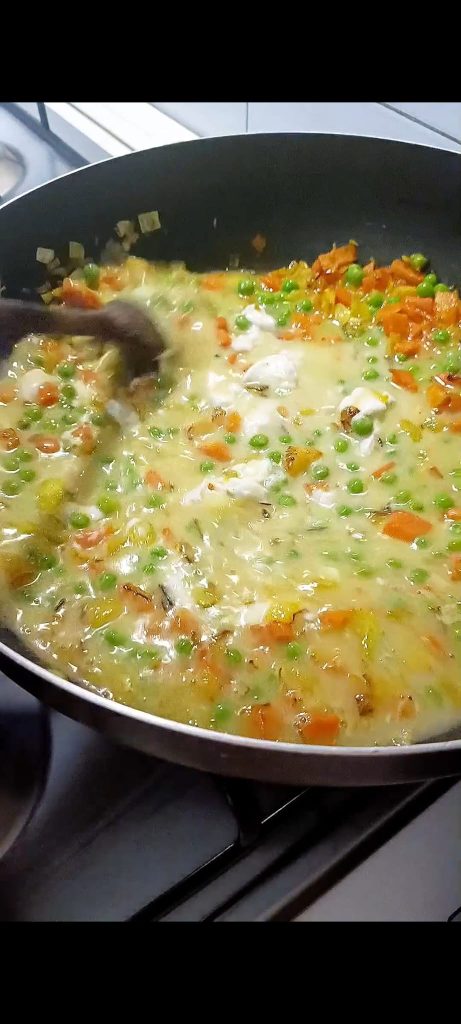 Voeg kokosmelk en bouillon of heet water toe
