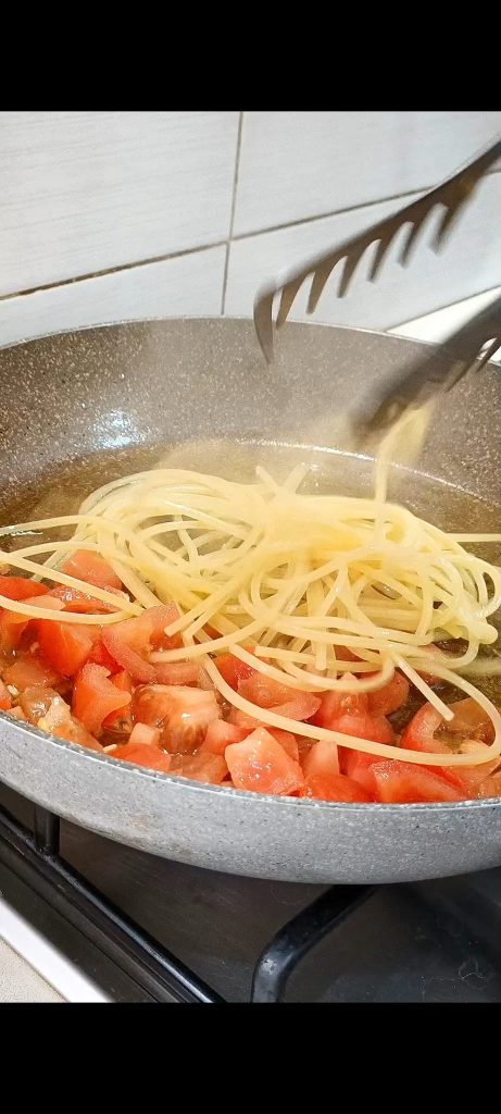 We gieten de al dente pasta in de pan