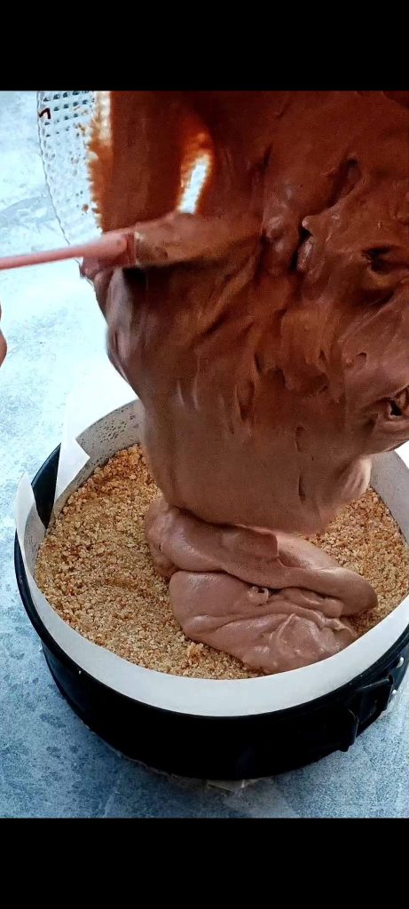 We gieten de crème op de koekjesbodem