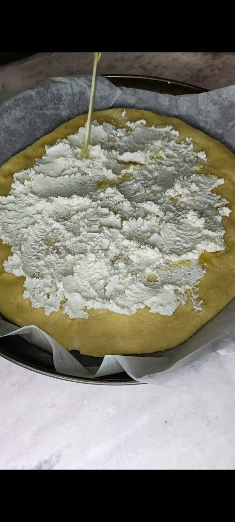 We smeren de ricotta op de pizzabodem