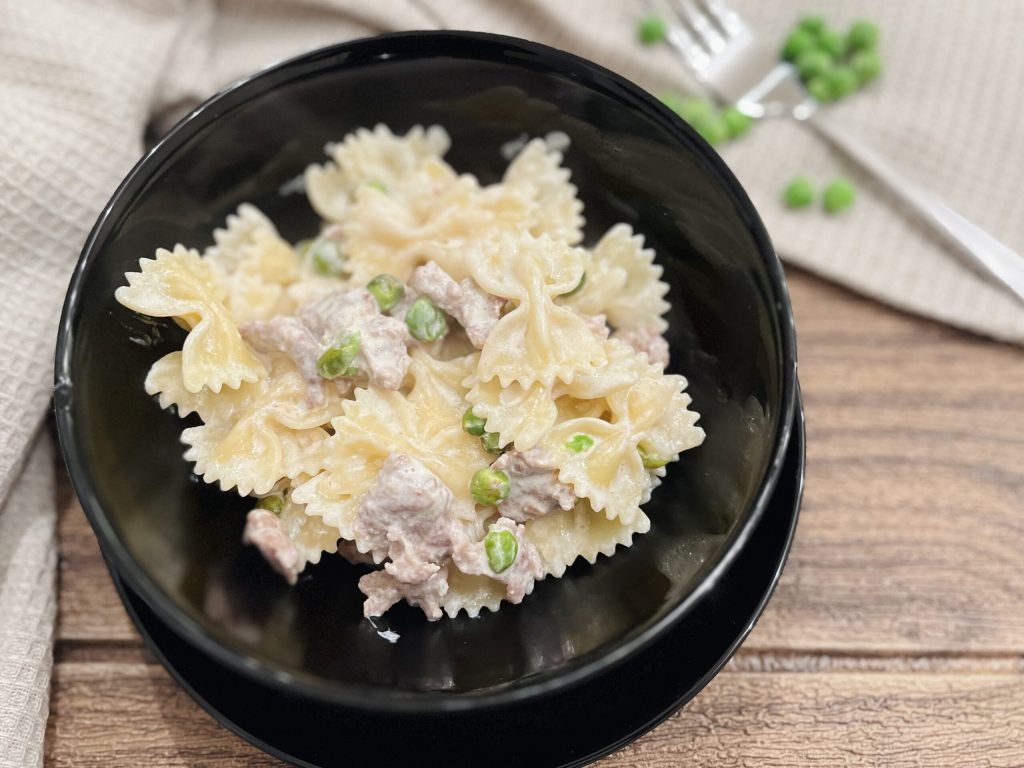 romige farfalle met worst en erwten