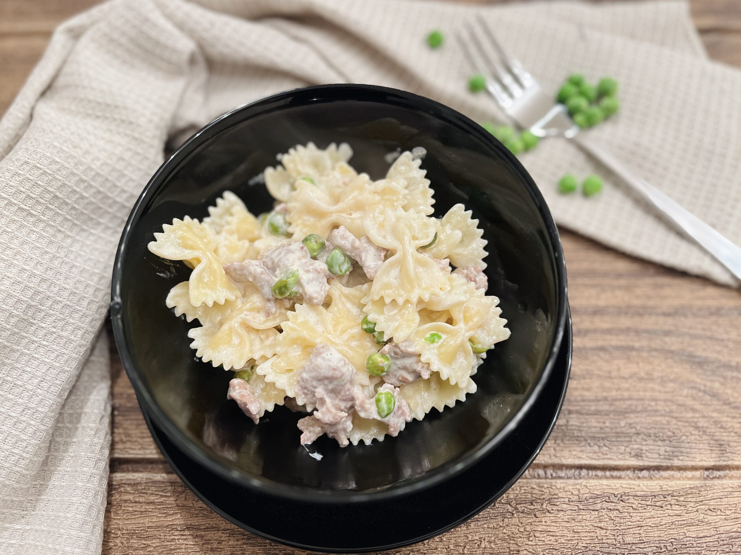 Romige farfalle met worst en erwten