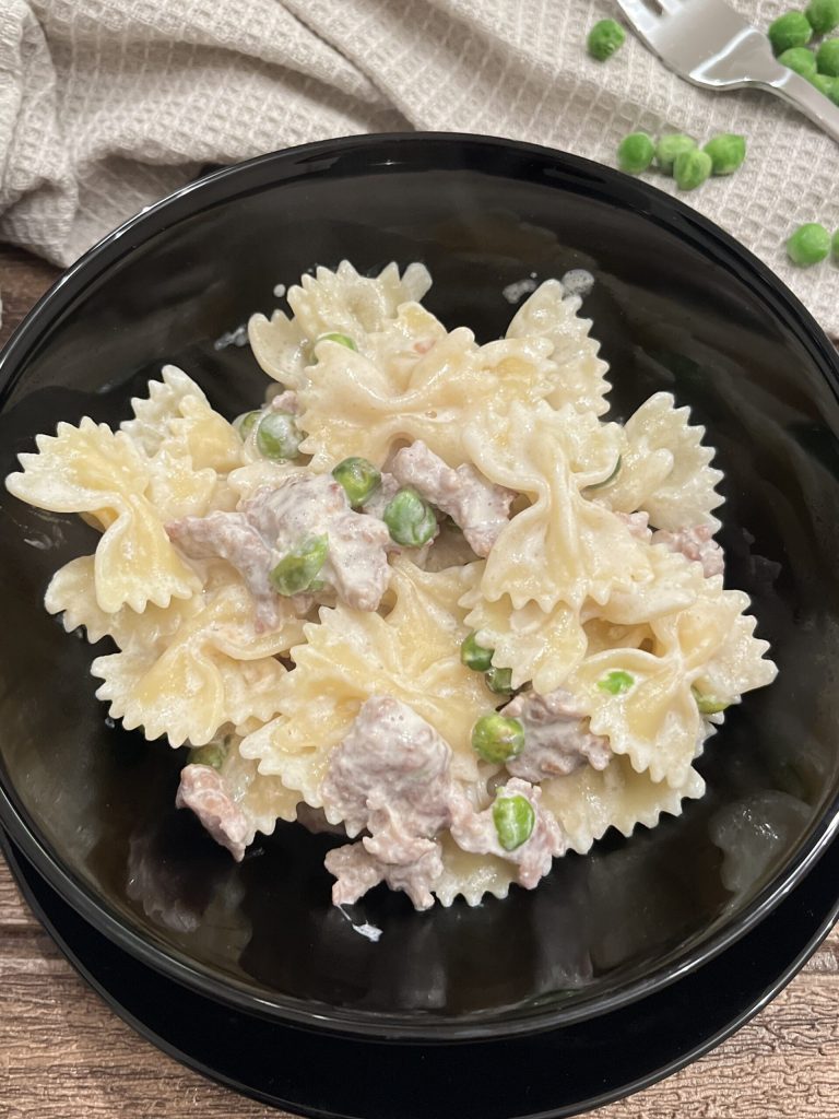 romige farfalle met worst en erwten