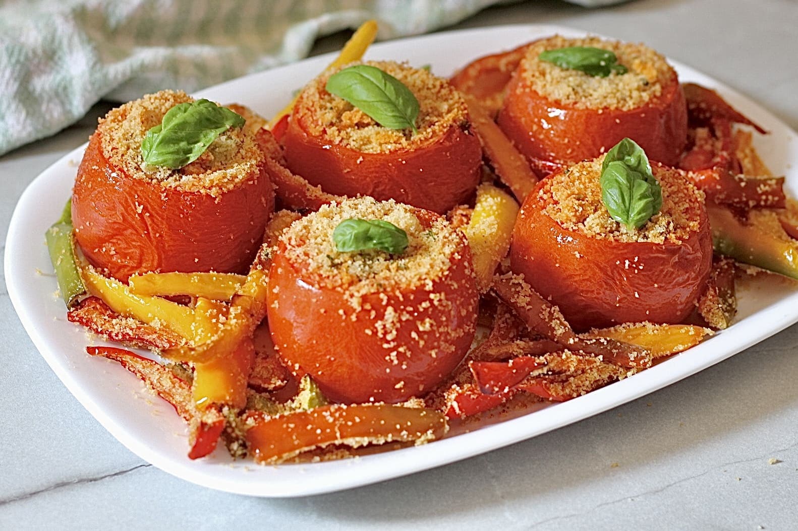 Siciliaanse tomaten op een bedje van gegratineerde paprika’s.