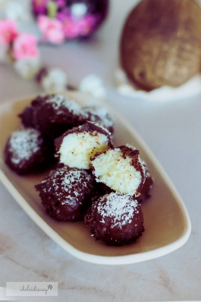 Kokosballetjes bedekt met pure chocolade op een ovale schaal, met zachte binnenkant en bestrooid met kokos