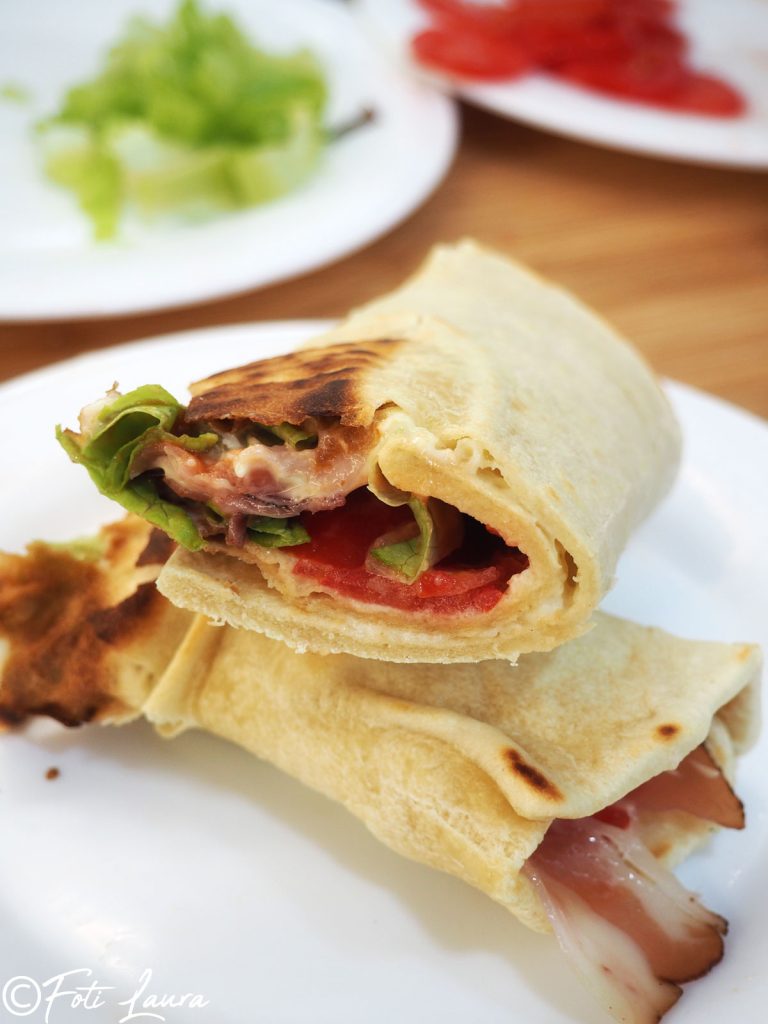 Piadina romagnola doorgesneden op wit bord