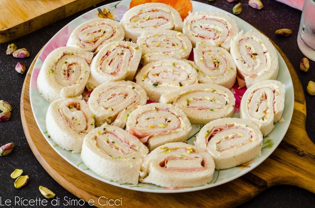 Rolletjes van sandwichbrood met mortadella en pistachenoten
