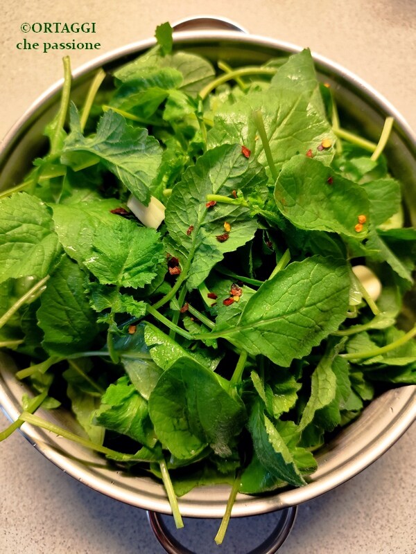 rauwe radijsbladeren in de pan met knoflook en chilipeper