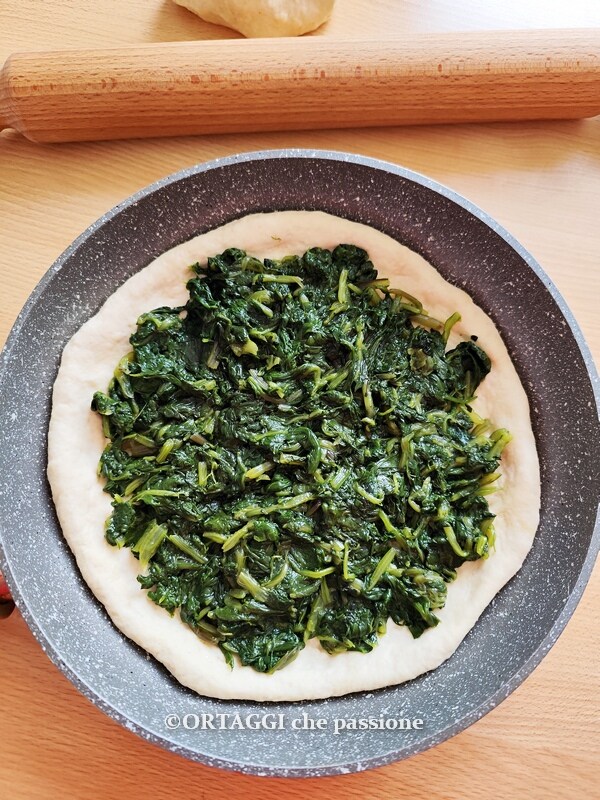 de focaccia in de pan vullen met groenten
