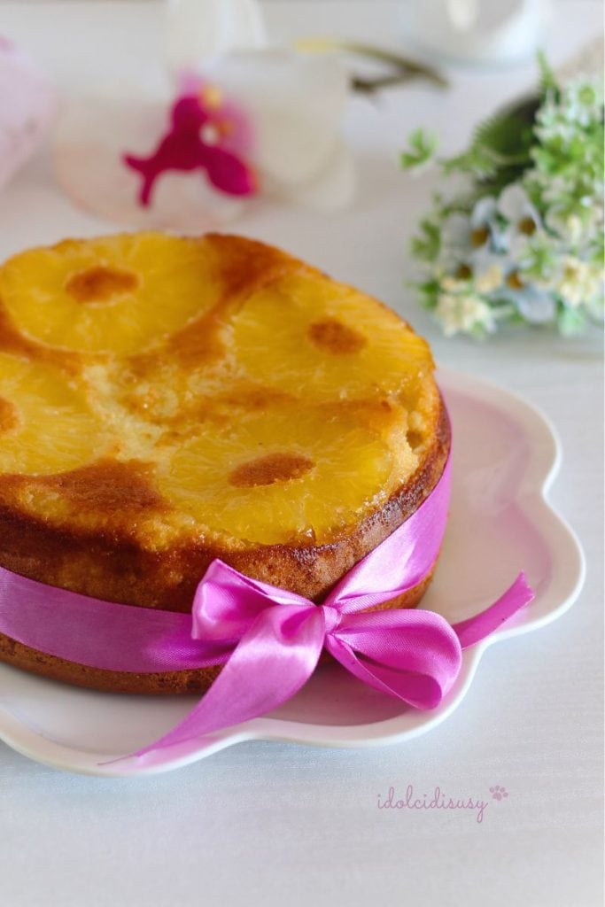 Omgekeerde ananastaart op wit bord, versierd met lint en gekarameliseerde ananas