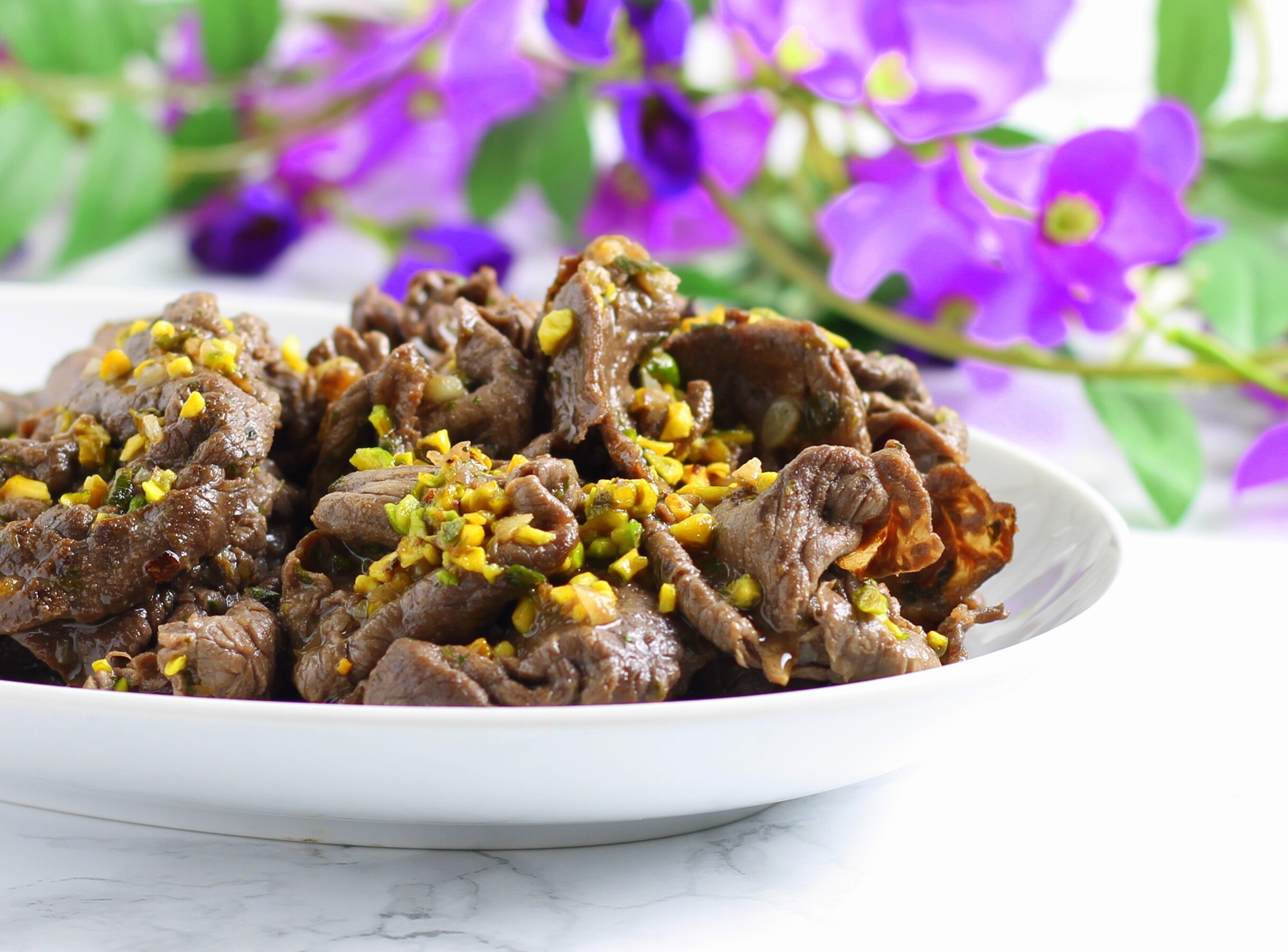 Dunne plakjes rundvlees met salmoriglio en pistachenoten