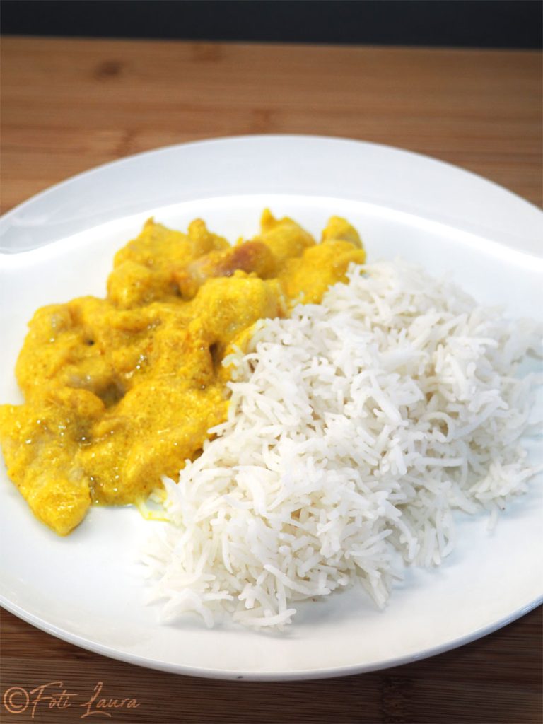 Basmati rijst geserveerd op een wit bord met curry kip