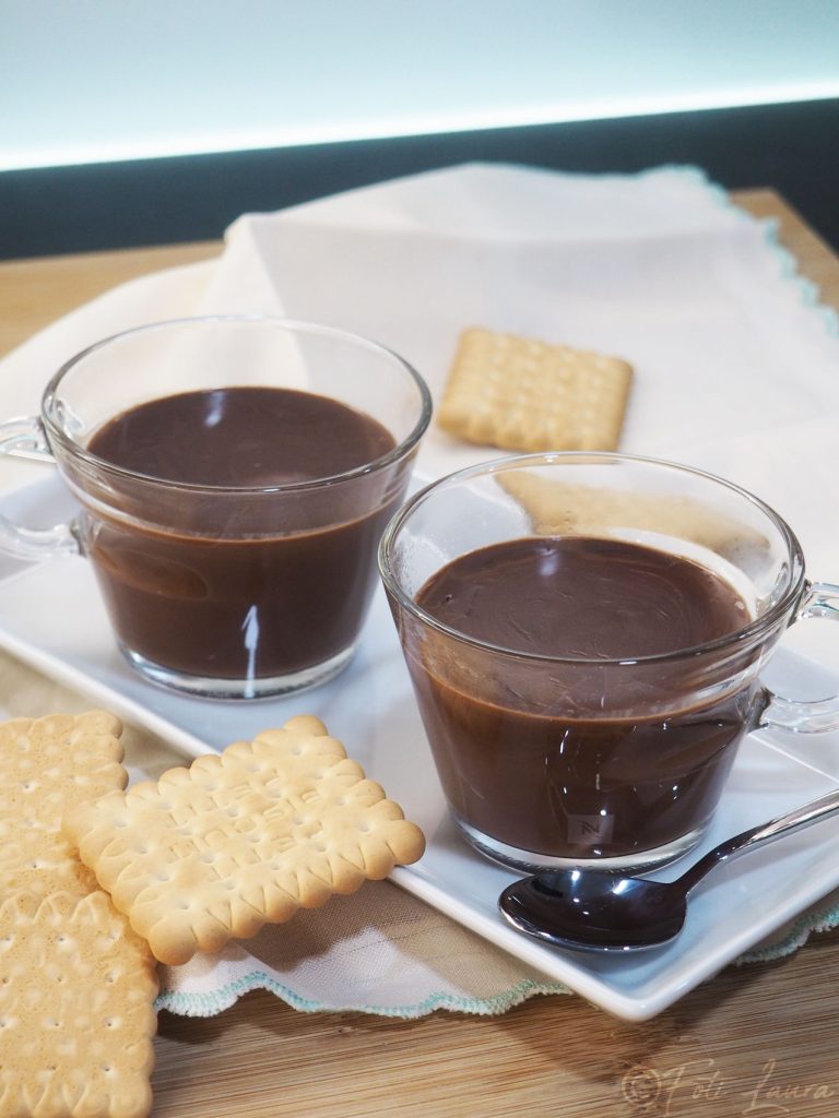 Twee kopjes zelfgemaakte warme chocolademelk met koekjes aan de zijkant