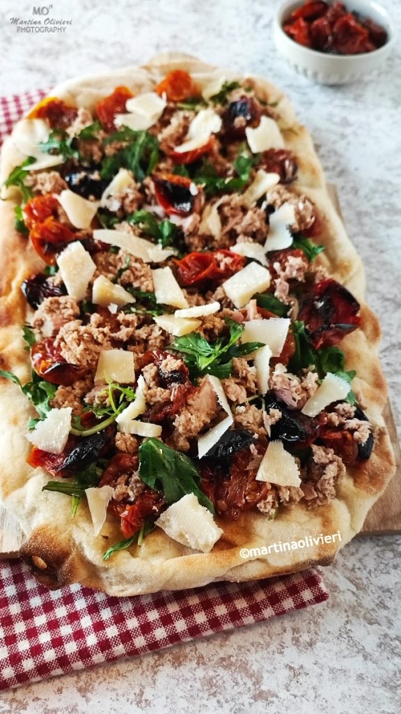 Witte pizza met tonijn, geroosterde tomaatjes en rucola