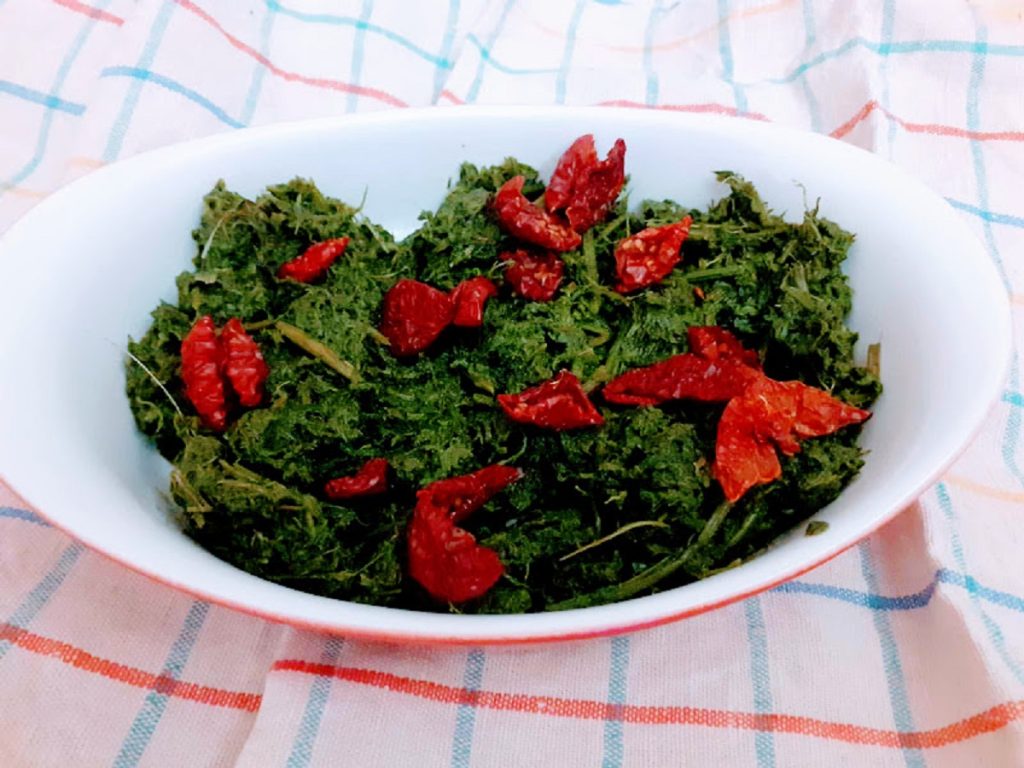 Wortelloof in de pan met zongedroogde tomaten