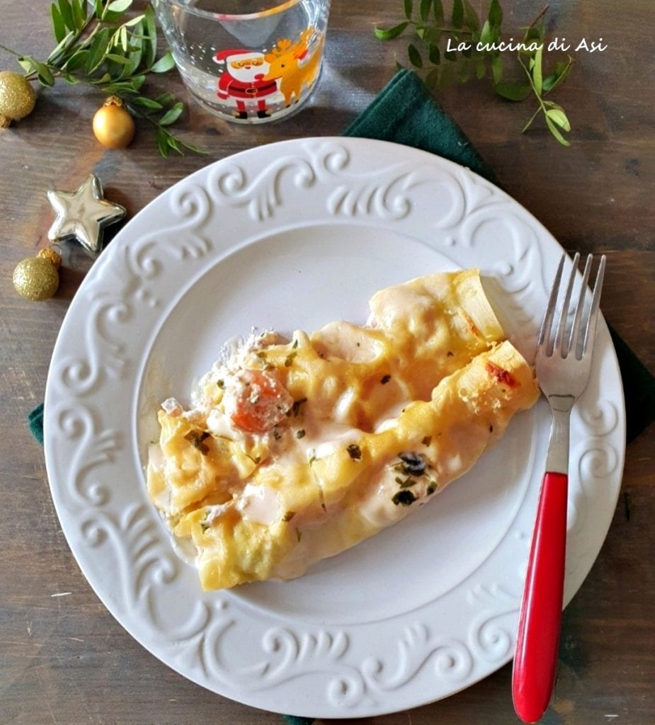 Cannelloni met zalm en garnalen gekruid met bechamel, ricotta, peterselie, geserveerd op de schotel en klaar om op tafel te zetten voor de kerstfeesten.