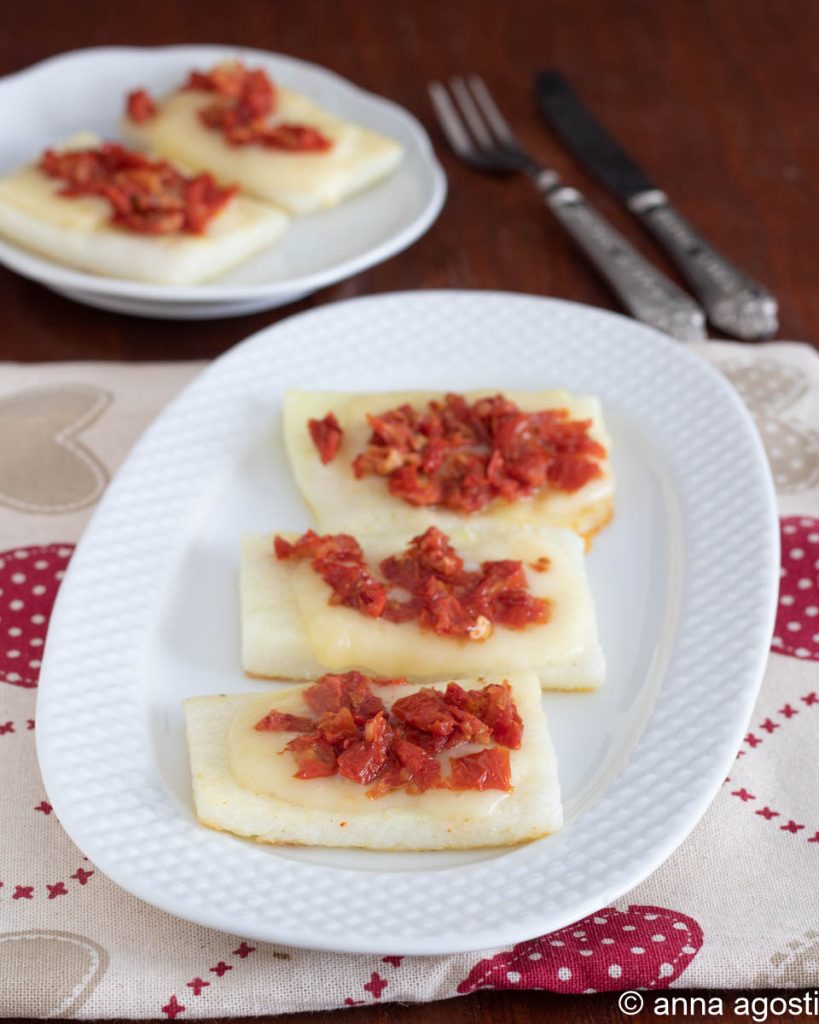 crostini van witte polenta met kaas en tomaten