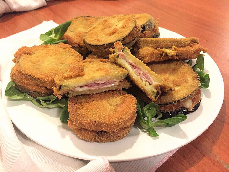 Gebakken aubergines gevuld met ham en kaas.