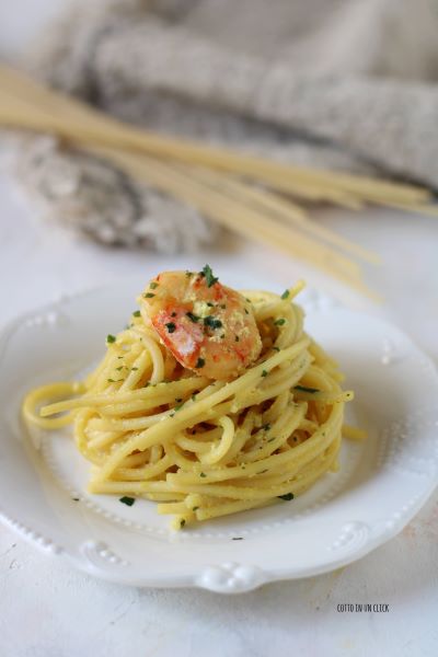 serveer de pasta met garnalen en kurkuma met gehakte peterselie