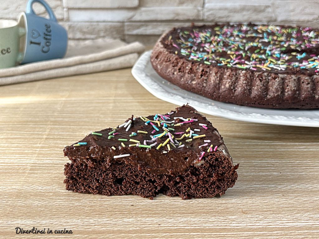 Zachte taart met cacao gevuld met banketbakkersroom met chocolade, gedecoreerd met veel gekleurde suikerhagelslag.