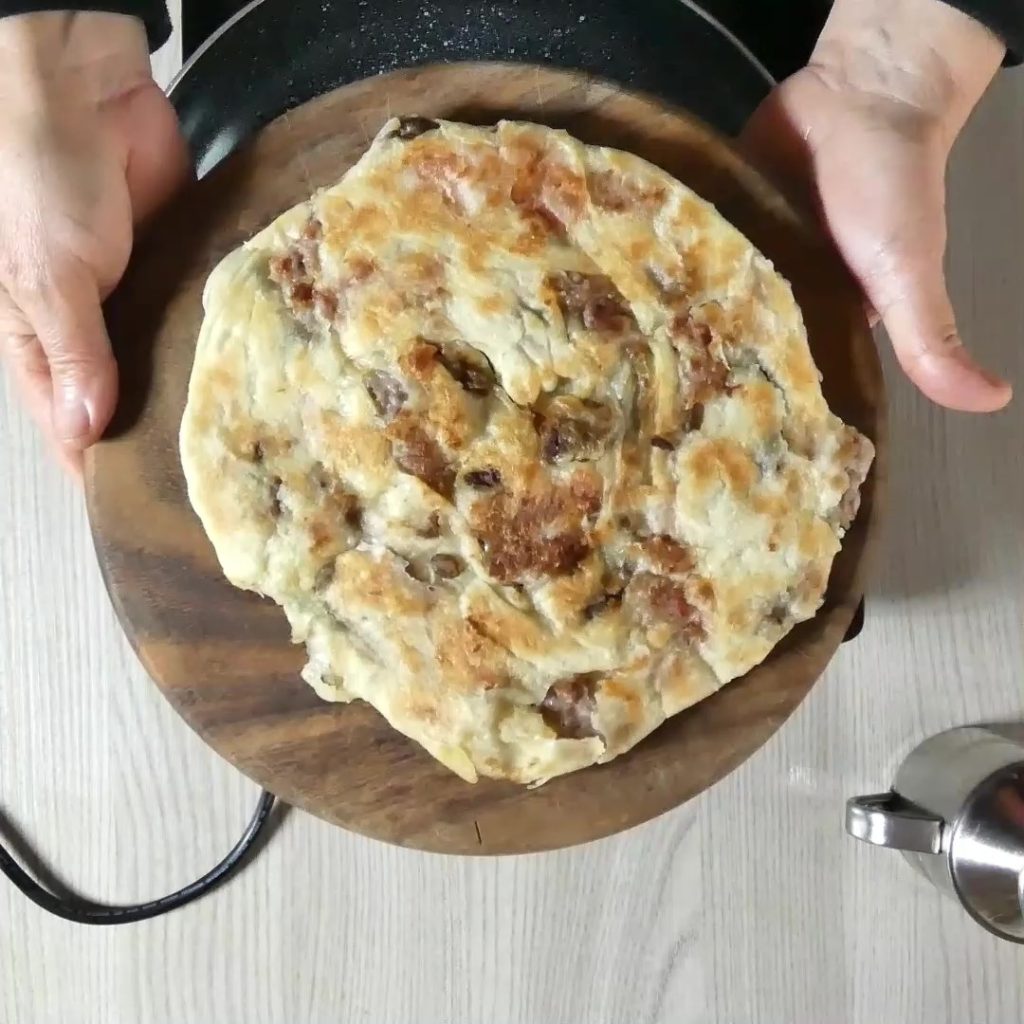 focaccia in de pan met worst en olijven pan gebakken