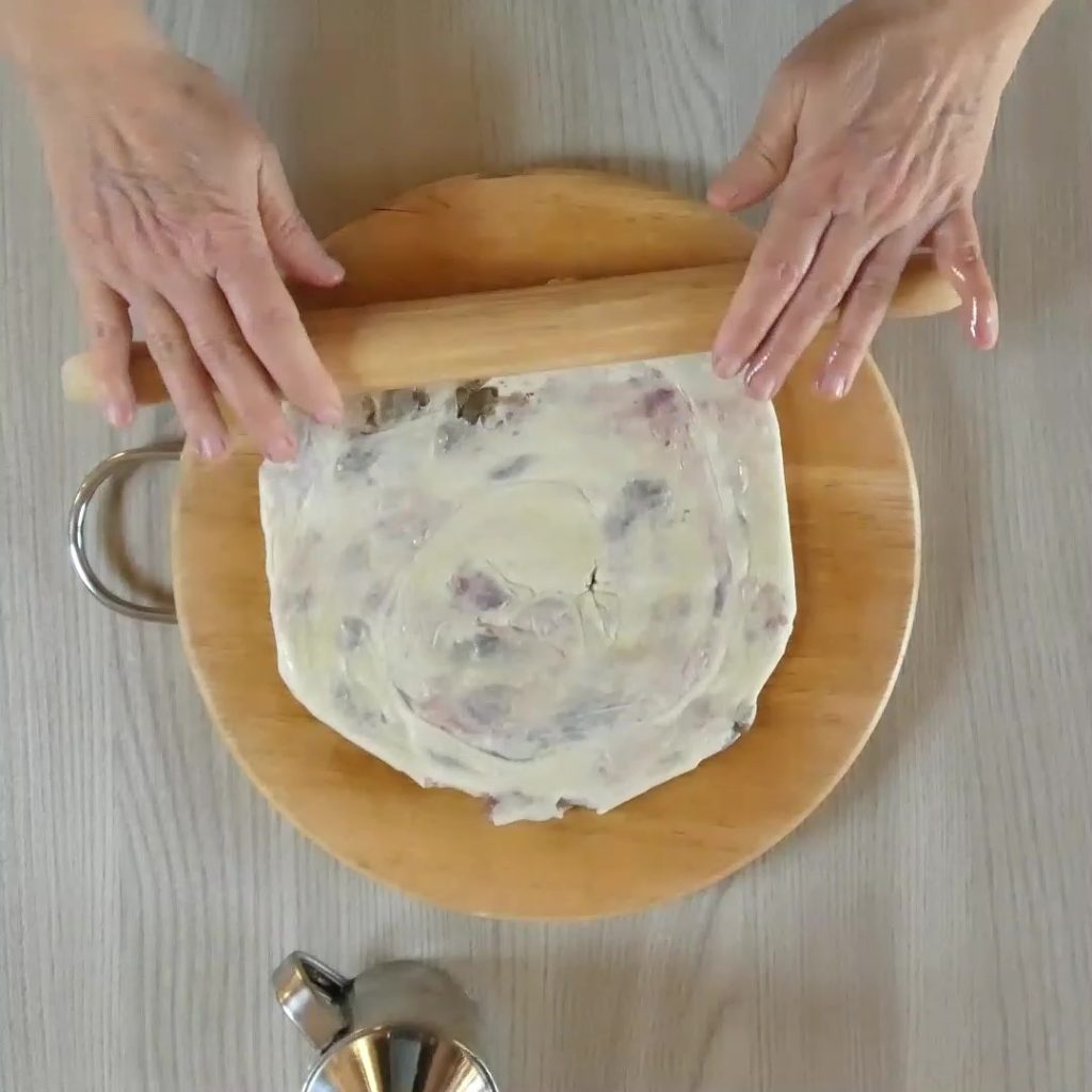 focaccia in de pan met worst en olijven slakkenhuis uitrollen