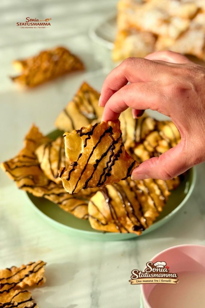 Dienblad met krokante Carnevale chiacchiere met bellen en donkere chocolade