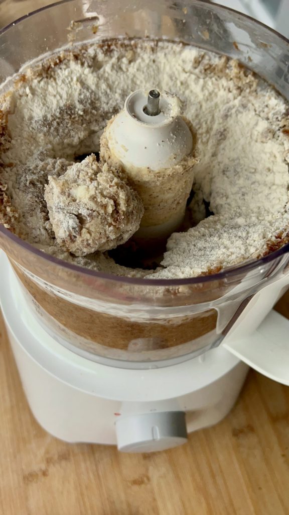 Ingrediënten voor suikervrije koekjes met rozijnen en amandelen in de keukenmachine