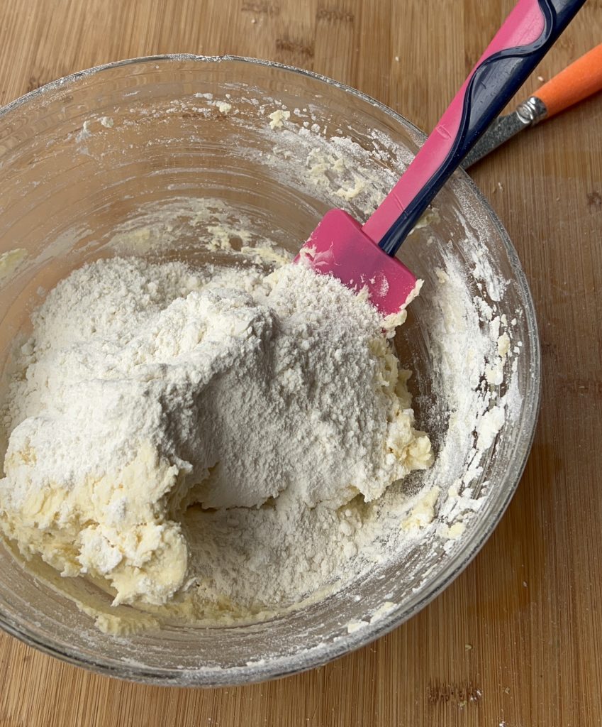 Toevoegen van de bloem aan het deeg voor de citroenkoekjes